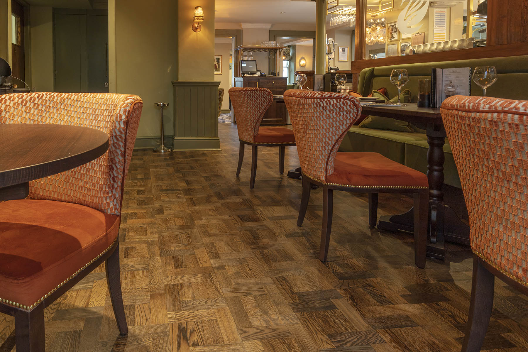 Stylish dining area at The Swan Pub, showcasing JackEvie’s Foxtrot Park basketweave parquet flooring with contemporary seating.