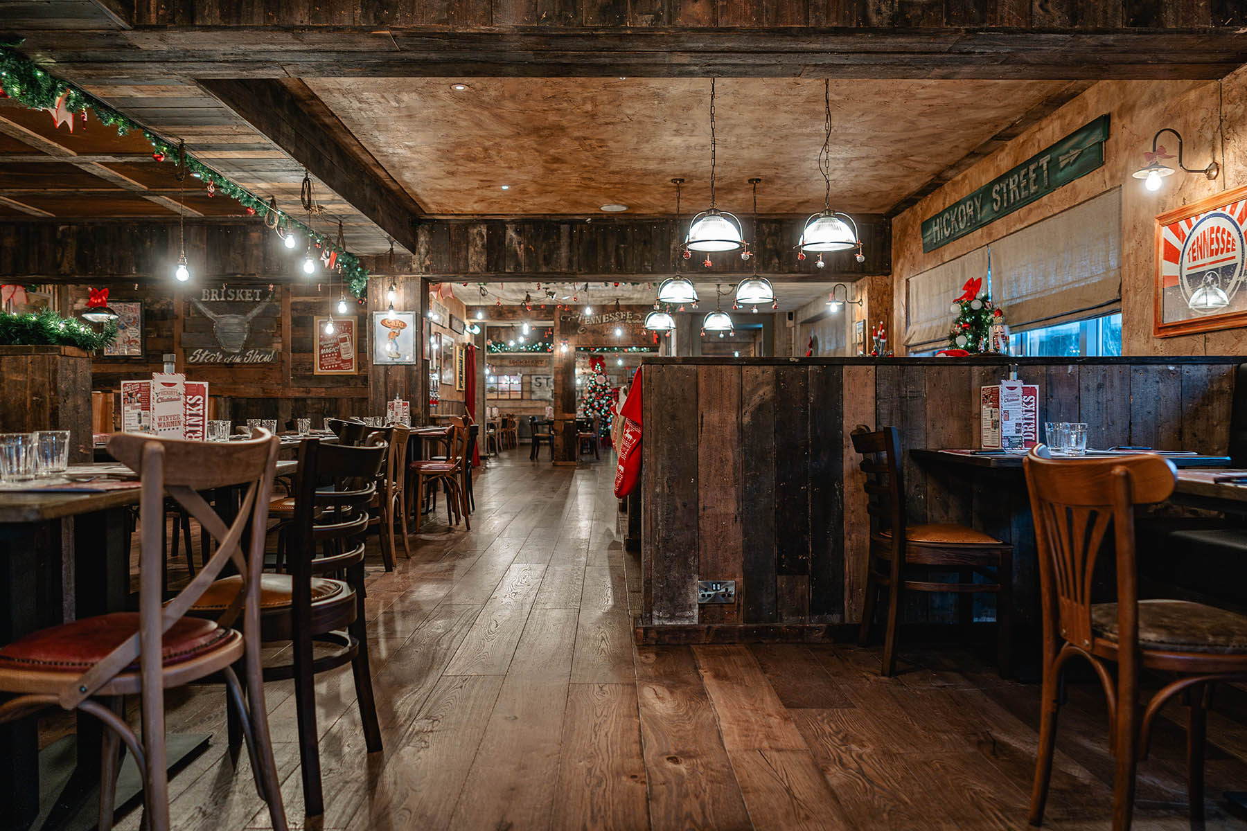 Earthy-toned wide plank flooring complementing wood paneling and furniture.