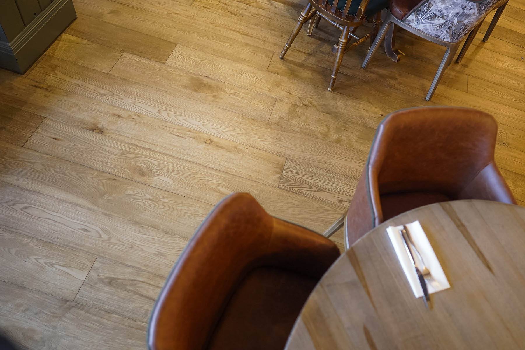 Close-up of Anstey Lane plank flooring with brushed, worn, and dented surface treatment, highlighting rustic-grade oak texture.