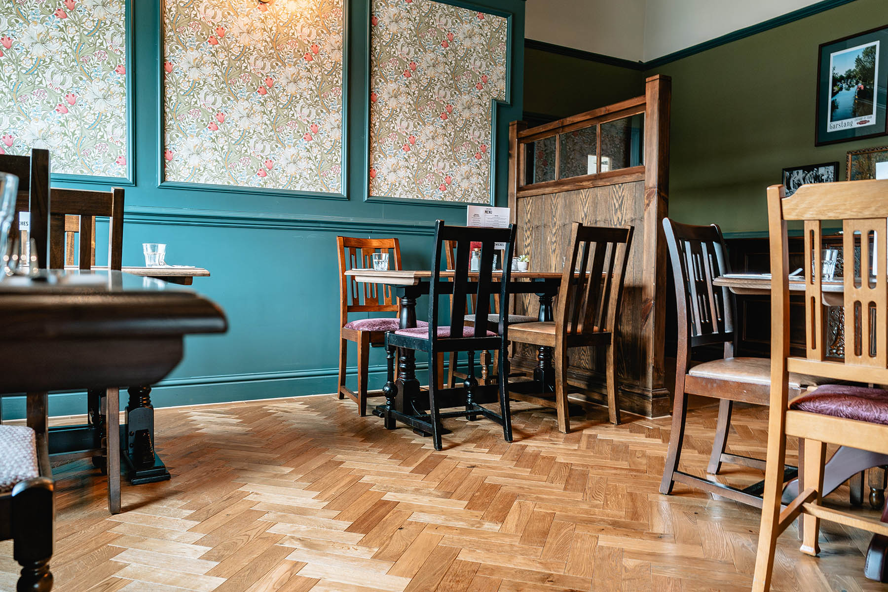 Rustic European oak flooring complementing William Morris-style tapestries.