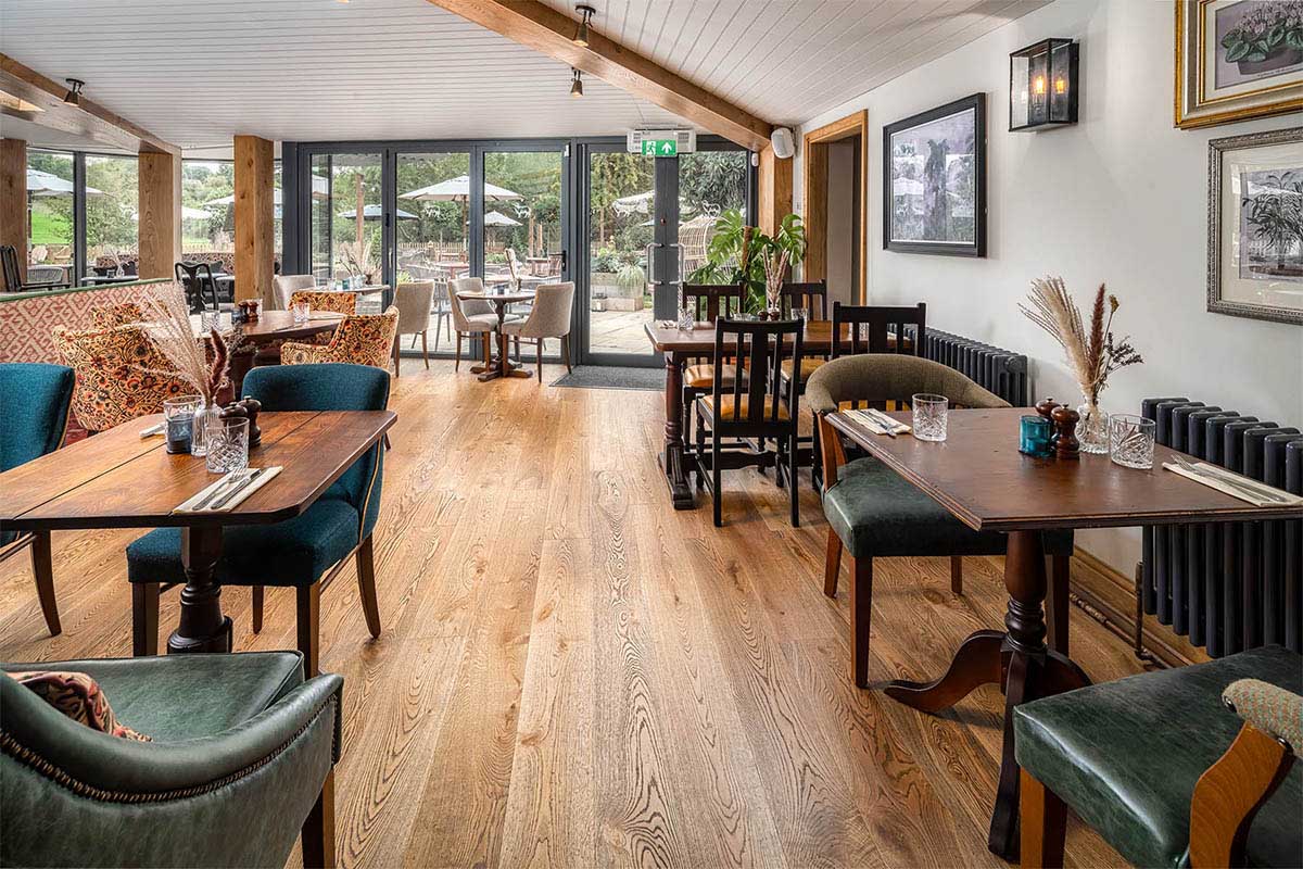 Stylish plank engineered wood floor inside an open-plan restaurant.